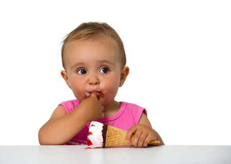 baby eating ice cream isolated on whiteの写真素材