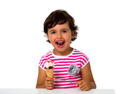 little girl eating ice cream isolated on whiteの写真素材
