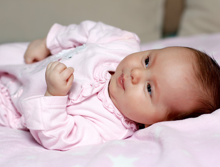Portrait of a baby baby lying in bedの写真素材
