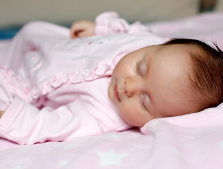 Portrait of a baby sleeping in bedの写真素材