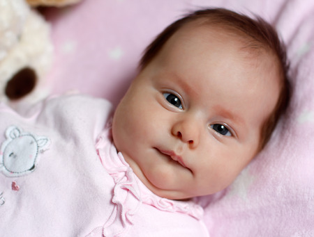 Portrait of a baby baby lying in bedの写真素材
