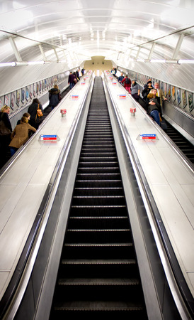 LONDON - OCT 24: People commuting on a moving stairs, going up and down, in the London underground.のeditorial素材