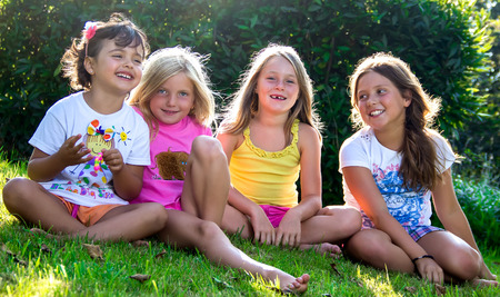 Portrait of cheerful little girls in a meadow.の写真素材
