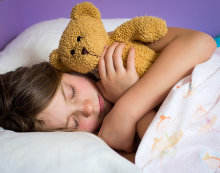 Portrait of a little girl sleeping in bedの写真素材