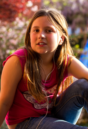 Little girl listening music outdoorsの写真素材
