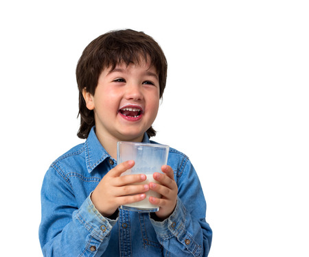 Little boy drinking a glass of milk isolated on whiteの写真素材