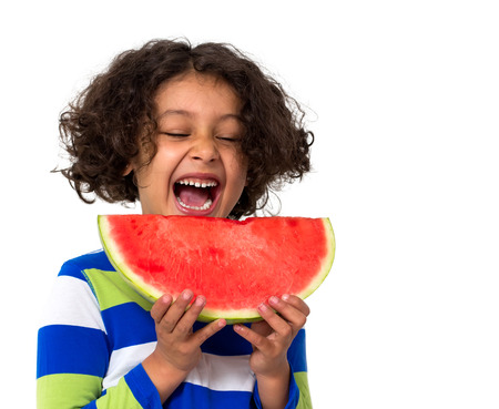 Little girl eating watermelon isolated on whiteの写真素材