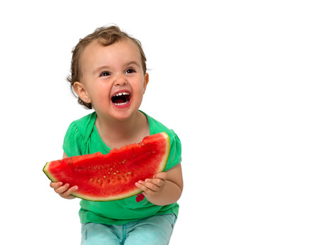Baby eating watermelon isolated on whiteの写真素材