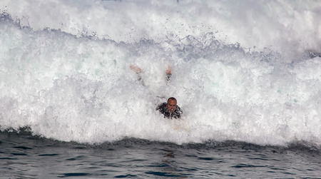 GIJON, SPAIN  Sep, 2014:  Young athletes surfing on a beach located on the outskirts of GijÃ³n. Spain. September 28, 2014のeditorial素材