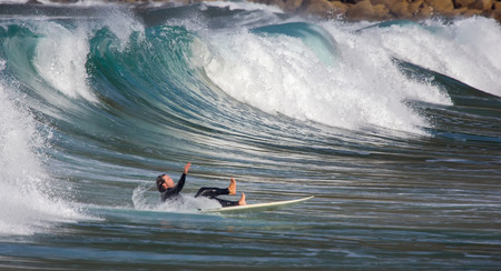 GIJON, SPAIN  Sep, 2014:  Young athletes surfing on a beach located on the outskirts of GijÃ³n. Spain. September 28, 2014のeditorial素材