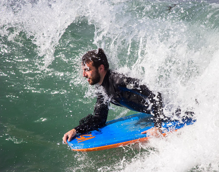 GIJON, SPAIN  Oct, 2014:  Athletes surfing on San Lorenzo beach located in GijÃ³n, in the north of...