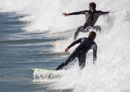 GIJON, SPAIN  Oct, 2014:  Athletes surfing on San Lorenzo beach located in GijÃ³n, in the north of...