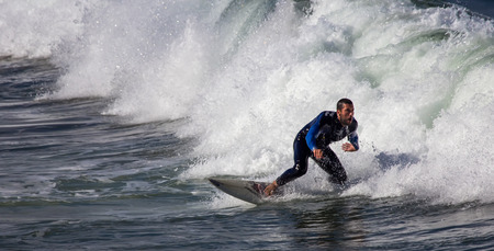 GIJON, SPAIN  Oct, 2014:  Athletes surfing on San Lorenzo beach located in GijÃ³n, in the north of...