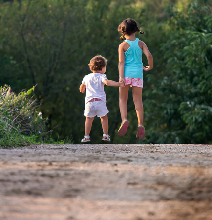 Two little girls strolling through the countrysideの写真素材