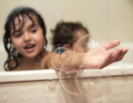 Two little girls taking a bath with a foamの写真素材