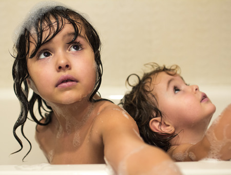 Two little girls taking a bath with a foamの写真素材