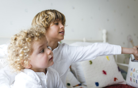 Portrait of two children blond brothers playing in their bedroomの写真素材