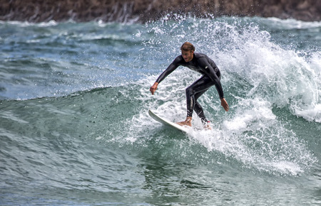 LLANES, SPAIN  May, 2015: Surfer participating in the CACONTEST 2015 on Ballota beach located in Asturias, in the north of Spain. May, 16, 2015のeditorial素材