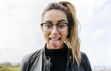 Expressive woman sticking out her tongueの写真素材