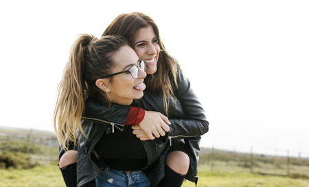 Two smiling women having fun outdoorsの写真素材