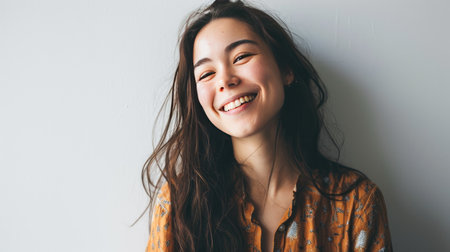 Portrait of young happy woman looks in camera on white backgroundの素材