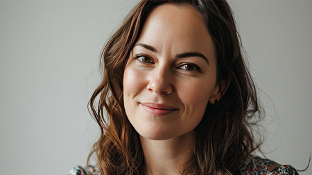 Portrait of a happy middle-aged woman looks in camera on white background.の素材
