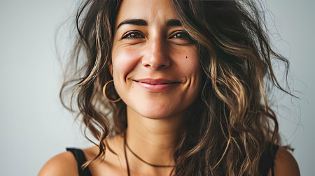 Portrait of a happy middle-aged woman looks in camera on white background.の素材