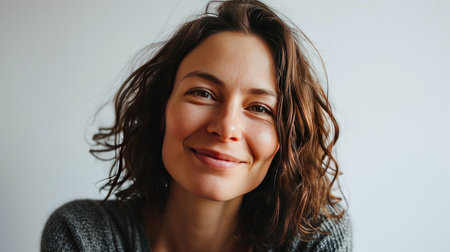 Portrait of a happy middle-aged woman looks in camera on white background.の素材