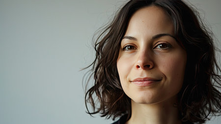 Portrait of a happy middle-aged woman looks in camera on white background.の素材