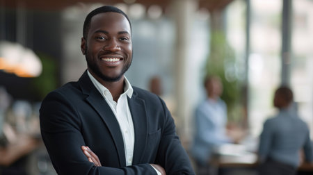 Portrait of a handsome smiling black businessman boss standing in his modern business company office.の素材