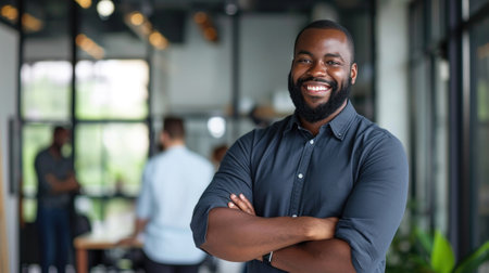 Portrait of a handsome smiling black businessman boss standing in his modern business company office.の素材