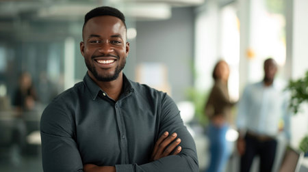 Portrait of a handsome smiling black businessman boss standing in his modern business company office.の素材