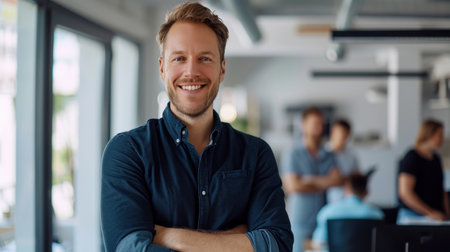 Portrait of a handsome smiling businessman boss standing in his modern business company office.の素材