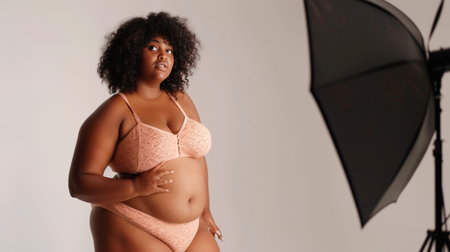 Confident Plus-Size Model in Elegant Lace Lingerie on a Pastel Backgroundの素材