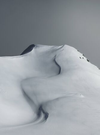 Dynamic and cold winter scenery of a snowy hill after a blizzard