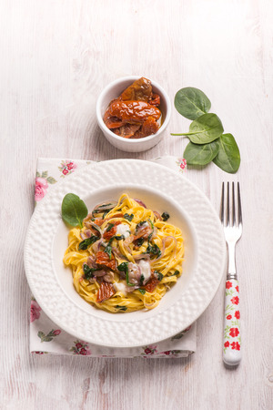 tagliatelle with fresh spinach gorgonzola cheese and dried tomatoesの写真素材