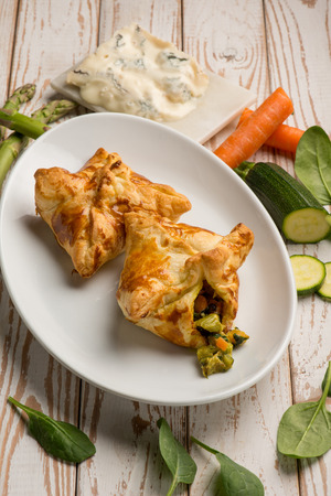 puff pastry filled with gorgonzola cheese asparagus zucchinis and carrotsの写真素材