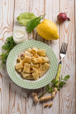 pasta with cram sauce lemon peel peanuts and parsleyの写真素材