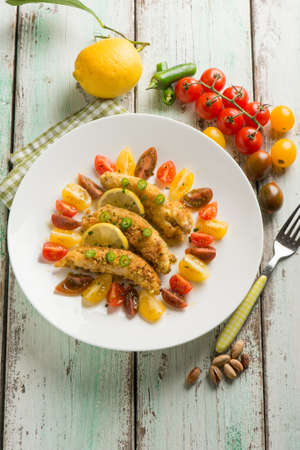 breaded chicken fillet with tomato saladの写真素材