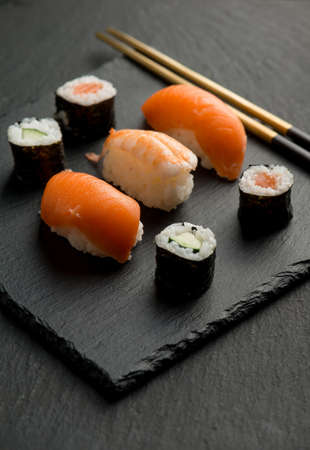 sushi with chopstick over black stoneの写真素材