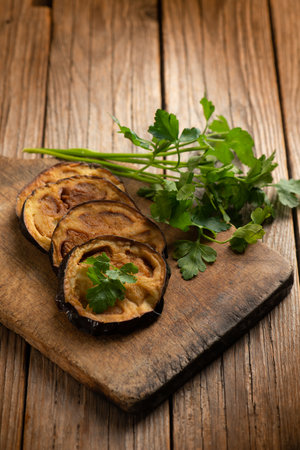 Baked eggplant with parsley on a wooden background. Selective focus.の写真素材