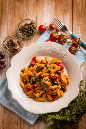 pasta with sword fish tomato black olives and capersの写真素材