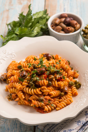 pasta with tuna tomatoes capers and black olivesの写真素材