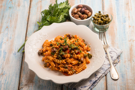 pasta with tuna tomatoes capers and black olivesの写真素材