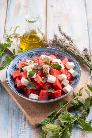 watermelon salad with feta cheese mint and lavender flowersの写真素材
