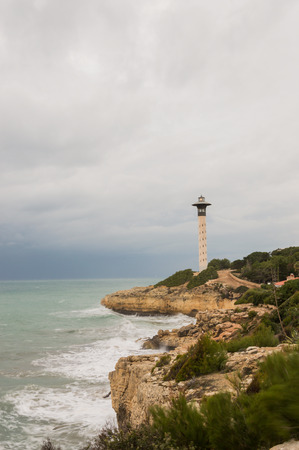 Lighthouse and coastline at Torredembarraの写真素材