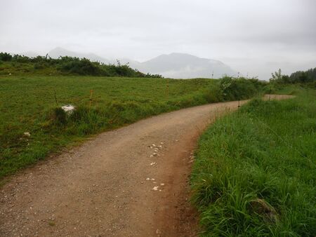 dirt road in rainy day with clouds in the backgroundの写真素材