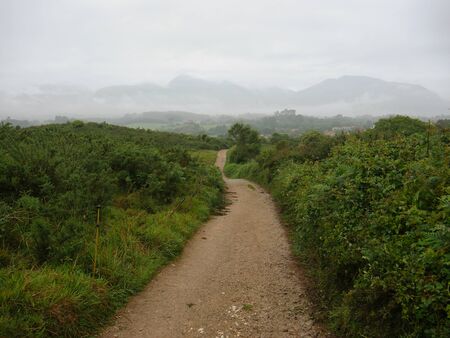 dirt road in rainy day with clouds in the backgroundの写真素材