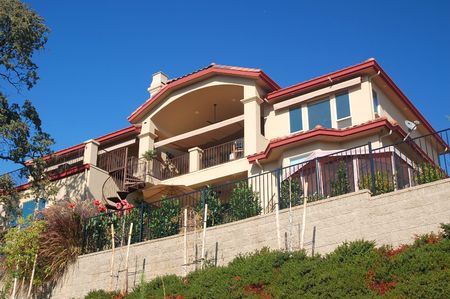 An upscale house on the hillside, with a spiral stairway in the frontの写真素材