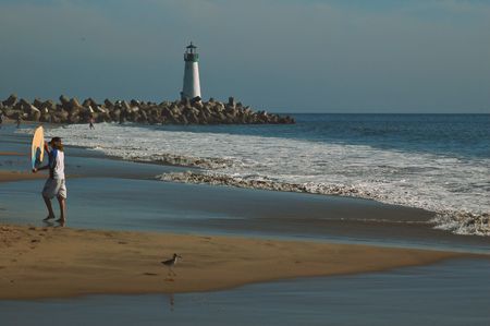 Boy holding a surfboard on the beach in Santa Cruz, Californiaの写真素材